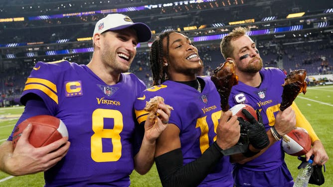 Minnesota Vikings' Kirk Cousins, Justin Jefferson, and Adam Thielen eat turkey legs on the field after defeating the New England Patriots at U.S. Bank Stadium in Minneapolis.
