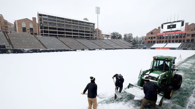Colorado workers clear the snow off the field as Deion Sanders prepared to open a new era in Boulder