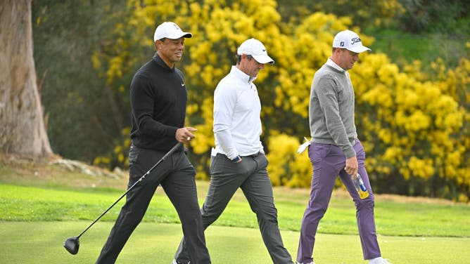 Tiger Woods, Rory McIlroy, and Justin Thomas walk together along the 13th hole during the 2nd round of The Genesis Invitational at Riviera Country Club in Pacific Palisades, California.