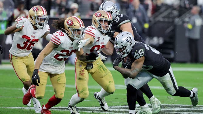 Nick Bosa and a pair of other 49ers defenders try to tackle 