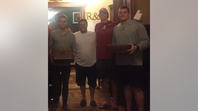 R&R Cigars owner Reagan Starner (second from left) next to then-Alabama quarterback Jake Coker at his left in cigar lounge in Tuscaloosa in 2015.