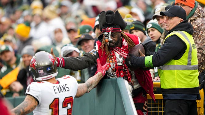 Mike Evans of the Tampa Bay Buccaneers hands the football to a fan following a touchdown during a game against the Green Bay Packers at Lambeau Field.