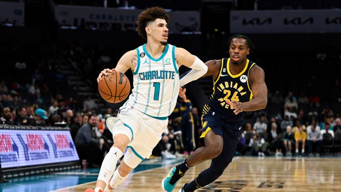 Charlotte Hornets All-Star LaMelo Ball dribbles past Indiana Pacers SG Buddy Hield at Spectrum Center in Charlotte, North Carolina.