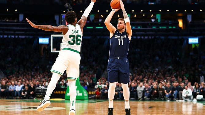 Dallas Mavericks' Luka Doncic shoots the ball over Boston Celtics PG Marcus Smart at TD Garden in Boston.