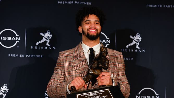 Caleb Williams poses with the Heisman Trophy after winning the award.