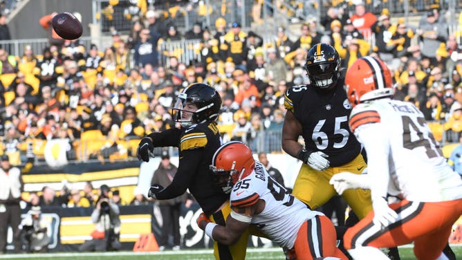 Steelers QB Kenny Pickett releases the ball as he is hit by Browns DE Myles Garrett at Acrisure Stadium.