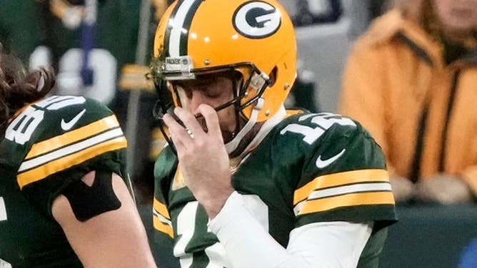 Aaron Rodgers adjusts his facemask