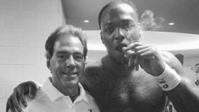 Alabama tailback Derrick Henry enjoys a victory cigar with coach Nick Saban after win over Tennessee in 2015.