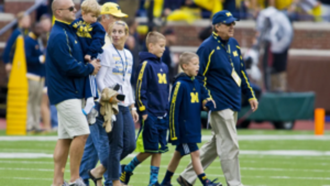 Lloyd Carr and family walk on field