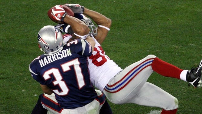 New York Giants' wide receiver David Tyree pins the ball to his helmet as he catches a 32-yard pass late in the fourth quarter of Super Bowl XLII against the New England Patriots at the University of Phoenix Stadium.