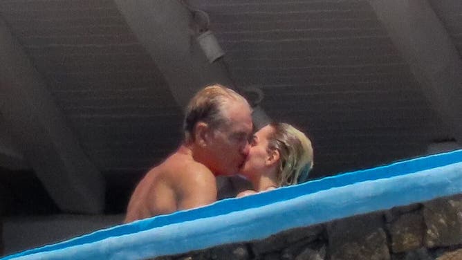 Actor Dolph Lundgren and his fiancee kiss while on vacation.