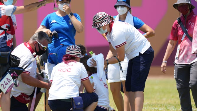 Jul 23, 2021; Tokyo, Japan;  Svetlana Gomboeva (ROC) is treated for heat exhaustion after completion of the archery ranking round during the Tokyo 2020 Olympic Summer Games at Yumenoshima Archery Field. Mandatory Credit: Jack Gruber-USA TODAY Network