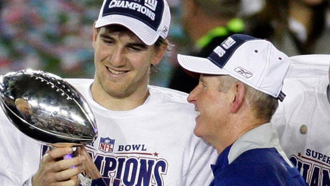 This Feb. 3, 2008, file photo shows New York Giants quarterback Eli Manning, left, and his coach Tom Coughlin looking at the Vince Lombardi Trophy as they celebrate after the Giants beat the New England Patriots 17-14 in Super Bowl XLII in Glendale, Ariz. 