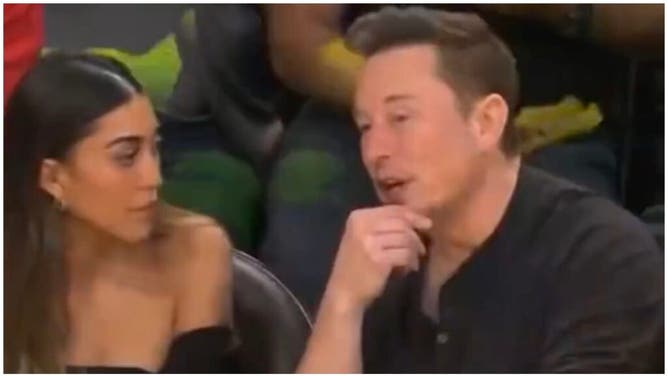 Elon Musk chats up mystery woman during Lakers/Warriors game. (Credit: Screenshot/Twitter Video https://twitter.com/cb_doge/status/1657236959381659648)