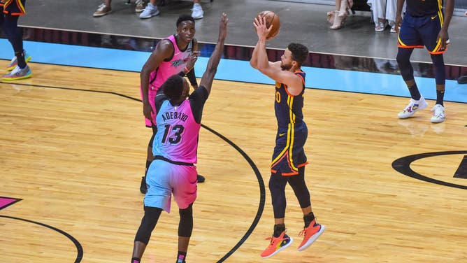 Miami Heat Bam Adebayo closing out on a 3-point attempt by Golden State Warriors Steph Curry.