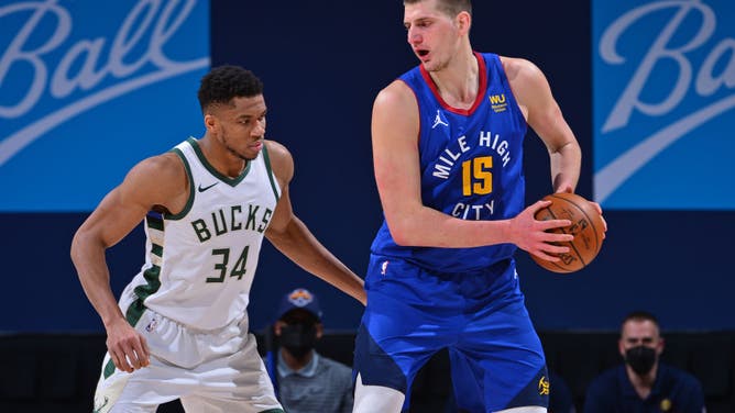 Bucks' Giannis defends Nuggets' Jokic at the Ball Arena in Denver, Colorado.