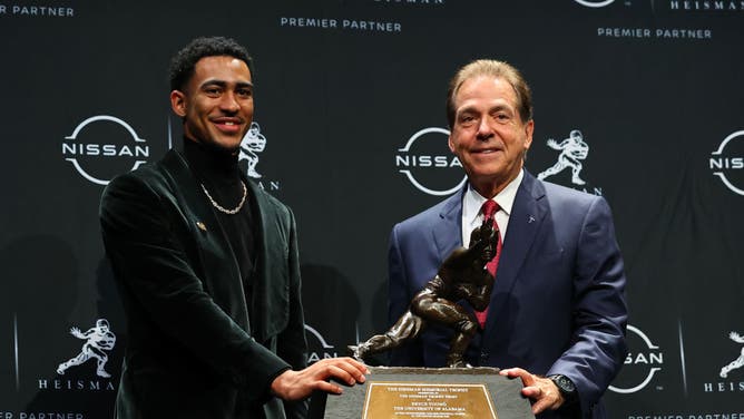 Young and Alabama coach Nick Saban pose with the 2021 Heisman Trophy at the Marriott Marquis in New York City.