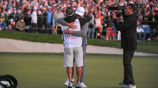 Luke List hugs his caddie after winning the playoff hole at the 2022 Farmers Insurance Open in San Diego, California.