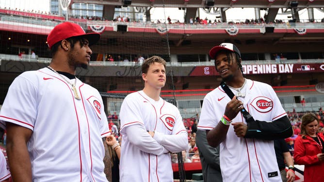 JaMarr Chase, Joe Burrow, and Tee Higgins of the Cincinnati Bengals stand on the field before the game between the Cleveland Guardians and the Cincinnati Reds at Great American Ball Park.