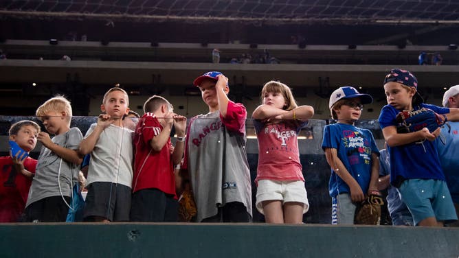 Young Texas Rangers fans wait for their turn to hopefully get a baseball after the Rangers win a game against the Detroit Tigers at Globe Life Field.