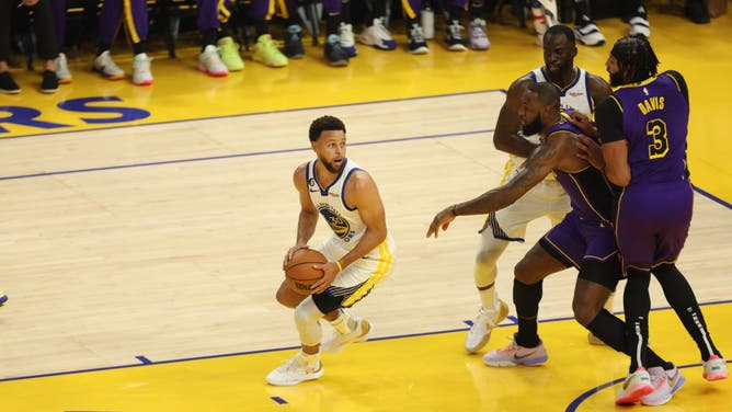 Warriors' Steph Curry handles the ball during the season opener vs. the Lakers with LeBron James and Anthony Davis playing defense at Chase Center.