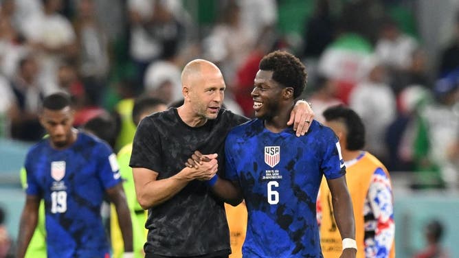 US Soccer head coach Gregg Berhalter celebrates with Yunus Musah following the team's World Cup win over Iran.