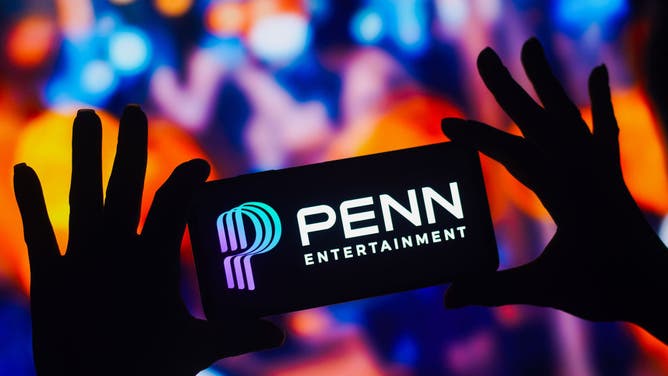 In this photo illustration, the Penn Entertainment logo is displayed on a smartphone mobile screen.