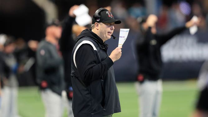 Atlanta Falcons head coach Arthur Smith calls in a play from the sidelines during an NFL game.