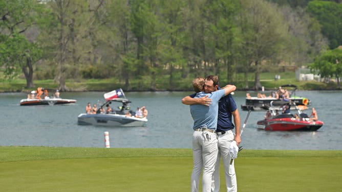 Sam Burns and Scottie Scheffler hug on the 14th green, after the third playoff hole, during the final day of the World Golf Championships (WGC)-Dell Technologies Match Play.