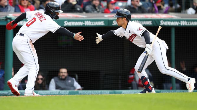 Guardians' Andres Gimenez high-fives Steven Kwan after scoring vs. the Mariners and the Cleveland Guardians at Progressive Field in Cleveland, Ohio.