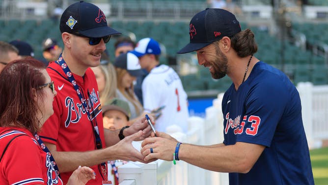 Atlanta Braves third baseman Charlie Culberson signs an autograph for a fan prior to a game against the Washington Nationals on June 9, 2023 at Truist Park in Atlanta, Georgia.