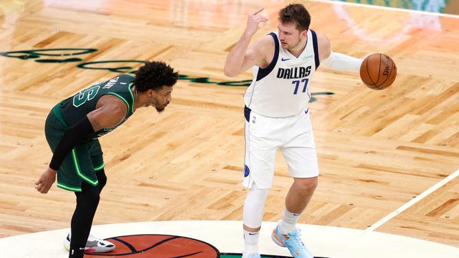 Dallas Mavericks PG Luka Doncic directs his team while being defended by Boston Celtics PG Marcus Smart at TD Garden in Boston.
