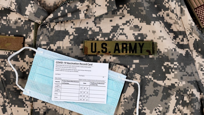 f547dbef-Covid 19 vaccination record card and personal facemask on US Army military uniform