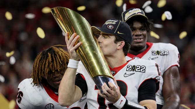 Georgia Bulldogs QB Stetson Bennett celebrates with the National Championship trophy beating the Alabama Crimson Tide in the 2022 CFP National Championship Game at Lucas Oil Stadium in Indianapolis.