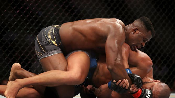 Francis Ngannou grapples on the ground with Ciryl Gane in their heavyweight title fight during the UFC 270 event at Honda Center in Anaheim, California.