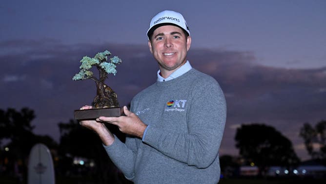 Luke List celebrates with the trophy after winning the The Farmers Insurance Open at Torrey Pines Golf Course in La Jolla, California.