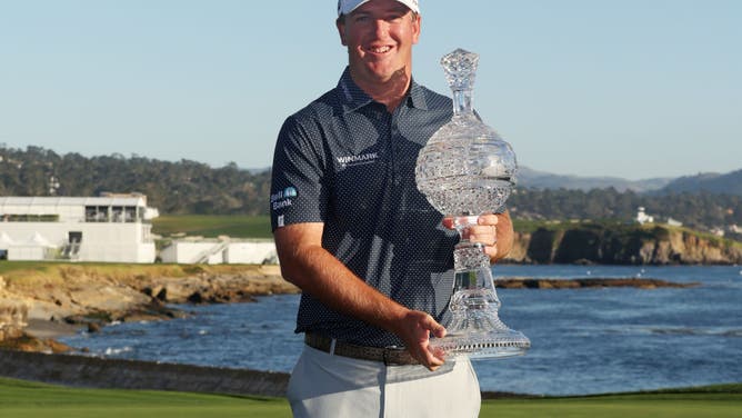 Tom Hoge celebrates with the trophy after winning the AT&T Pebble Beach Pro-Am at Pebble Beach Golf Links in Pebble Beach, California.