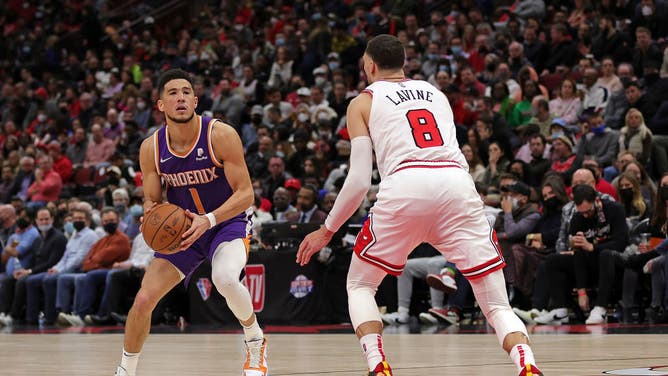 Devin Booker is defended by Bulls SG Zach LaVine at United Center in Chicago.