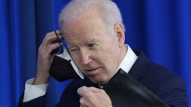 Joe Biden looking confused while putting on a useless mask
