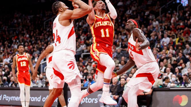 Atlanta Hawks PG Trae Young drives to the net on Toronto Raptors big Khem Birch and PF Pascal Siakam at Scotiabank Arena in Toronto, Canada.