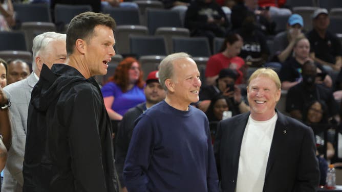 Retired quarterback Tom Brady, sportscaster Jim Gray and Las Vegas Raiders owner and managing general partner and Las Vegas Aces owner Mark Davis talk during halftime of a game between the Connecticut Sun and the Las Vegas Aces at Michelob ULTRA Arena.