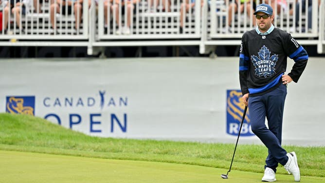 Corey Conners looks on from the 16th green while wearing a Toronto Maple Leafs' jersey during the 3rd round of the 2022 RBC Canadian Open at St. George's Golf and Country Club in Etobicoke, Ontario.