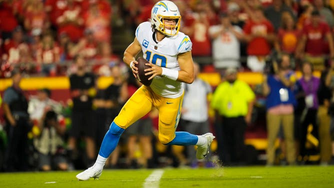 Los Angeles Chargers QB Justin Herbert rolls out to pass against the Kansas City Chiefs at GEHA Field at Arrowhead Stadium in Kansas City, Missouri.
