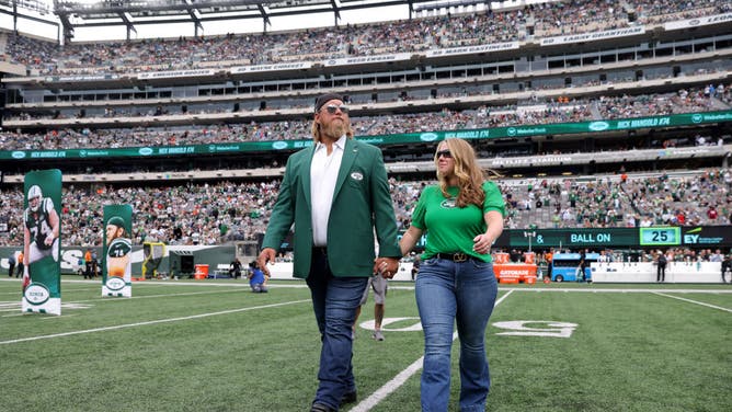 Former New York Jets player Nick Mangold walks on the field with his wife Jennifer Richmond as he is inducted into the Jets Ring of Honor.