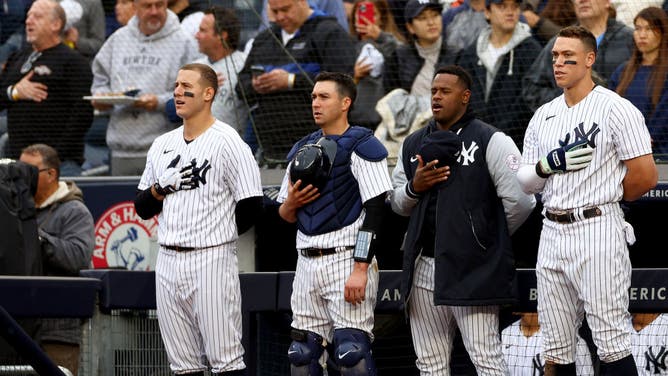 Anthony Rizzo, Kyle Higashioka, Luis Severino, and Aaron Judge of the New York Yankees stand for the singing of 'God Bless America' during a home game at Yankee Stadium.