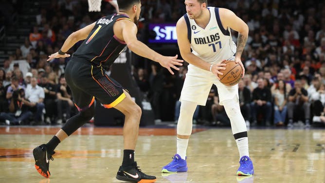 Dallas Mavericks All-Star Luka Doncic sizes up Suns All-Star Devin Booker at the Footprint Center in Phoenix, Arizona.