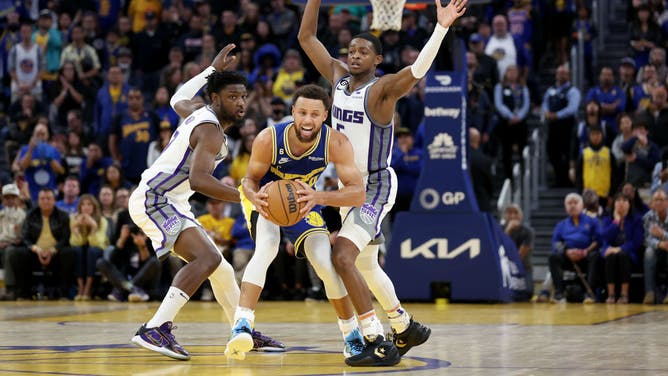 Warriors' Stephen Curry is defended by Kings big Chimezie Metu and PG De'Aaron Fox at Chase Center in San Francisco.