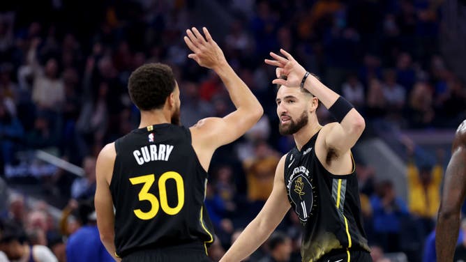 Golden State Warriors Stephen Curry high-fives Klay Thompson during their game against the Los Angeles Clippers at Chase Center on November 23, 2022 in San Francisco.
