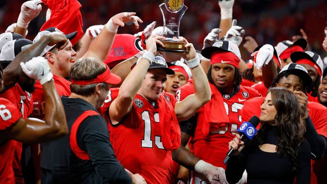 Georgia Bulldogs QB Stetson Bennett celebrates with the MVP trophy after defeating the LSU Tigers in the SEC Championship game at Mercedes-Benz Stadium in Atlanta, Georgia.