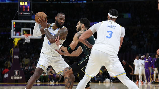 Lakers' LeBron James keeps the ball from Celtics' Jayson Tatum as Anthony Davis sets a screen at Crypto.com Arena in Los Angeles, California.